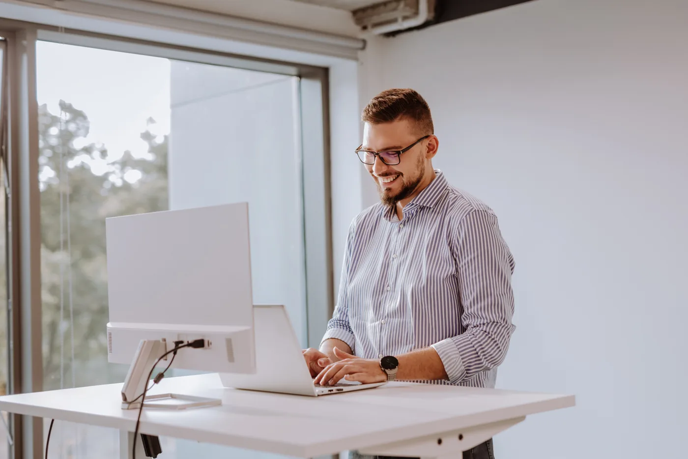 A Xelerit engineer working at a standing desk